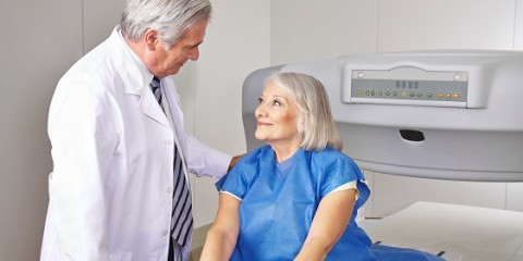 Doctor talking to senior patient prior to bone density measurement in radiology